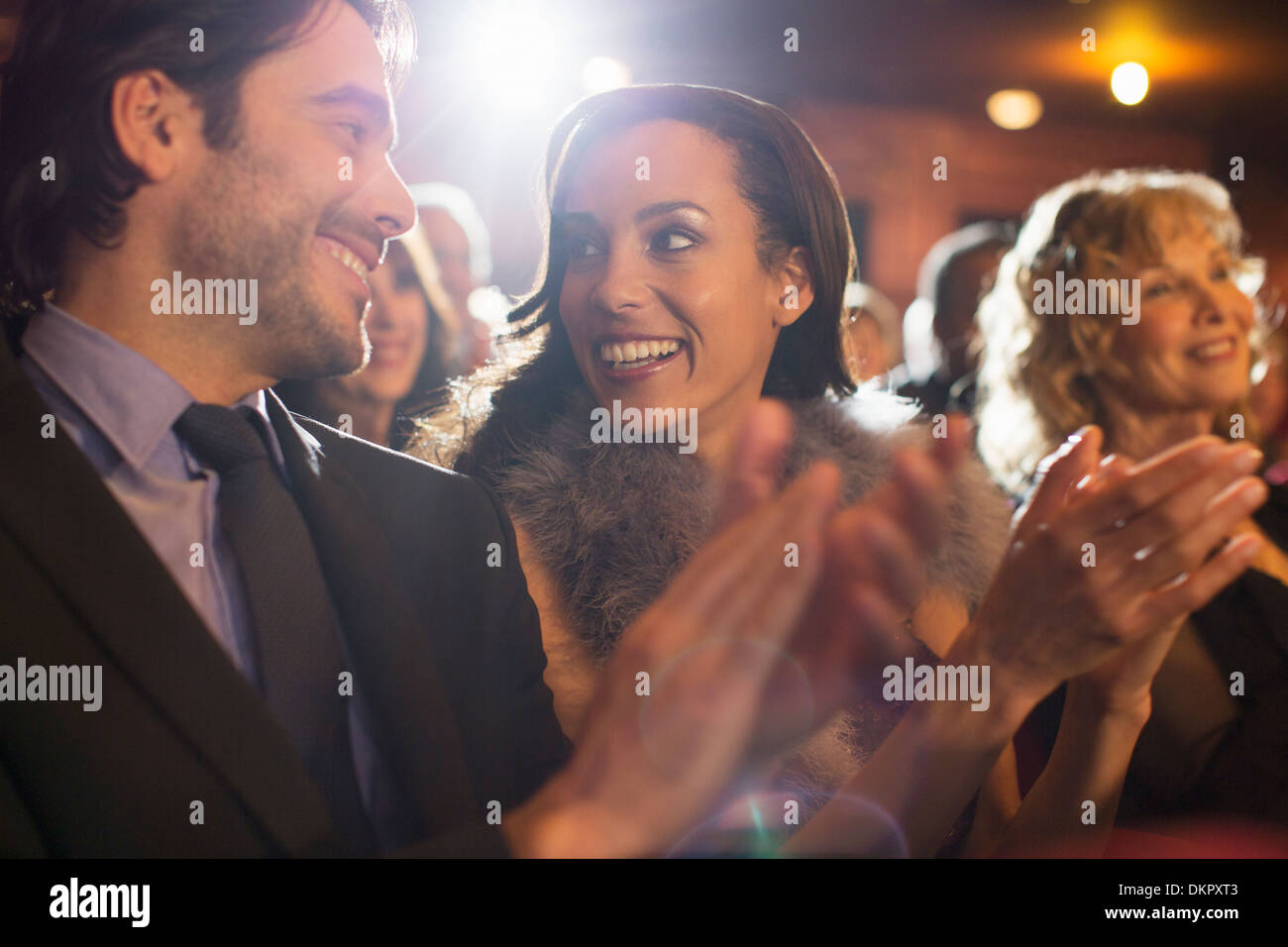 Close up of couple clapping in theater Stock Photo