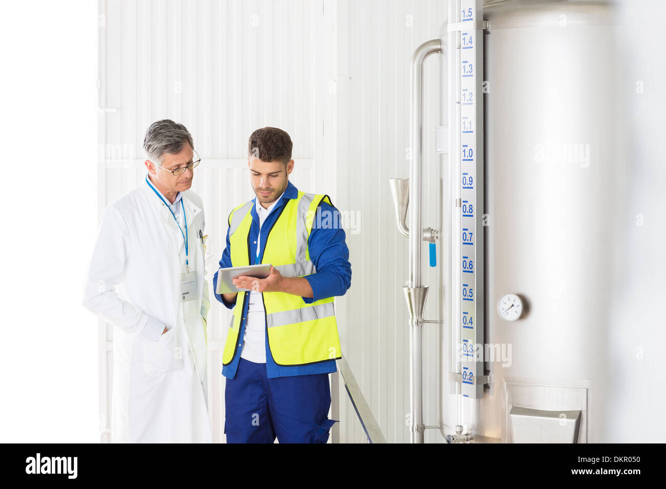 Worker and scientist talking in food processing plant Stock Photo