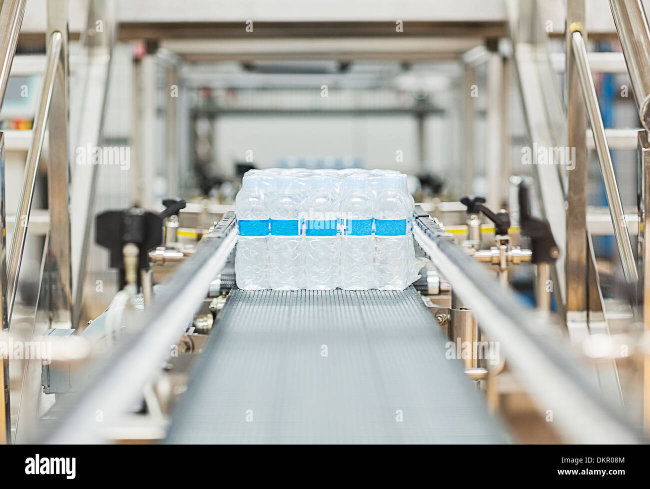 Water bottles on conveyor belt in factory Stock Photo