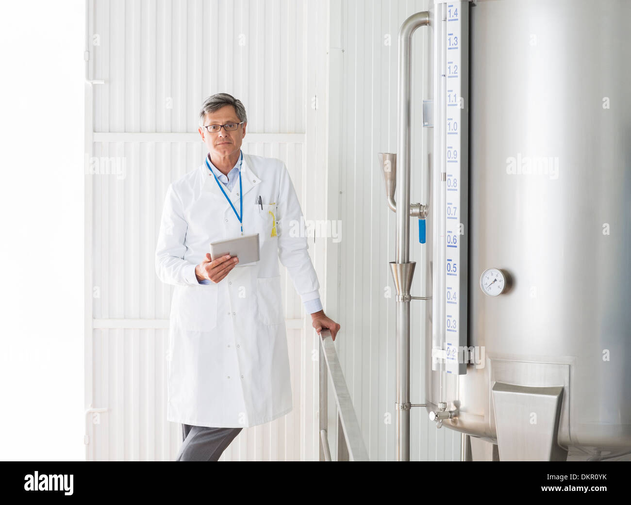 Scientist smiling in food processing plant Stock Photo