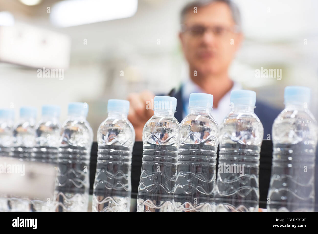 Supervisor examining bottles in factory Stock Photo