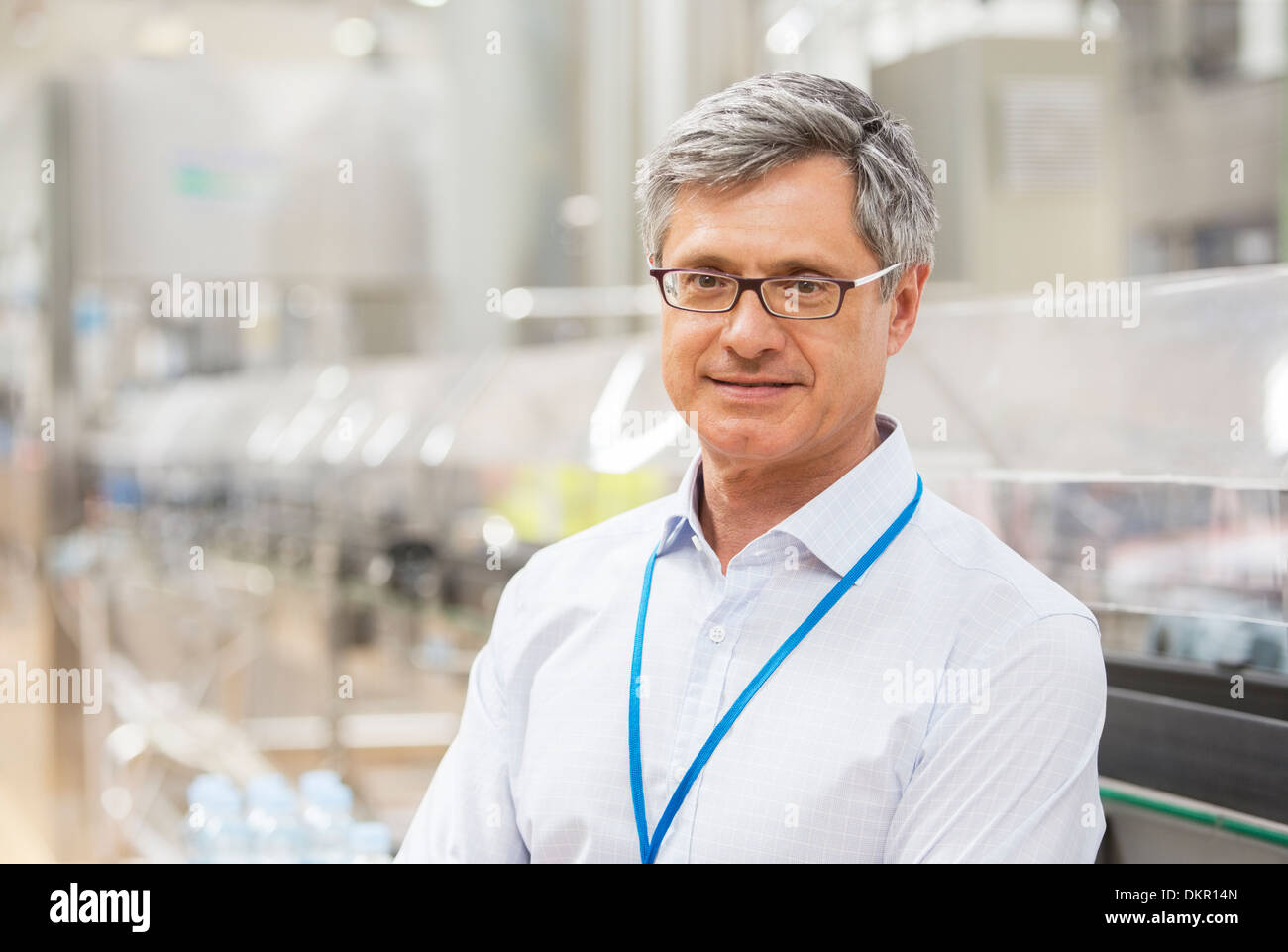 Businessman smiling in factory Stock Photo