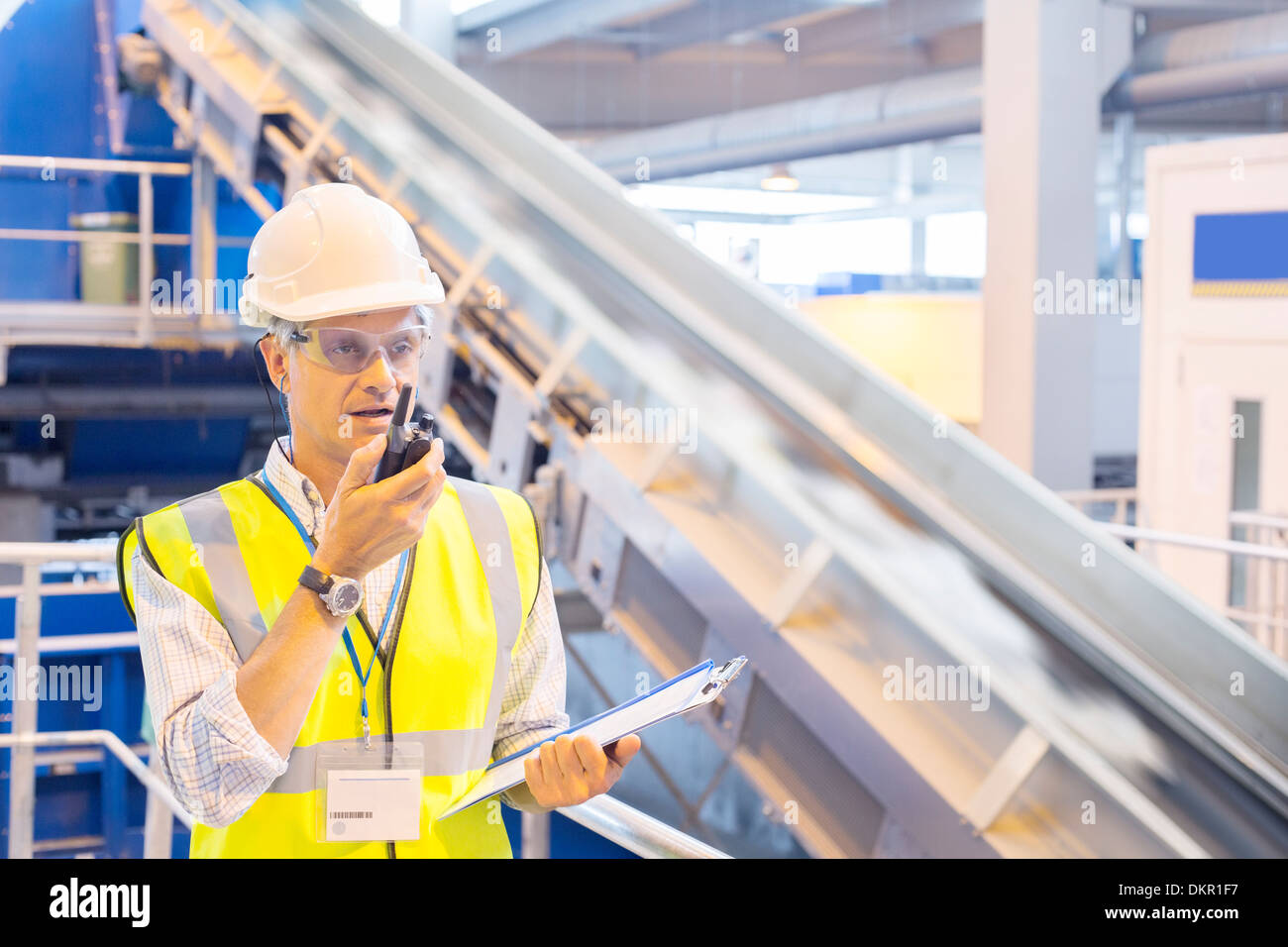 Supervisor using walkie-talkie in recycling center Stock Photo