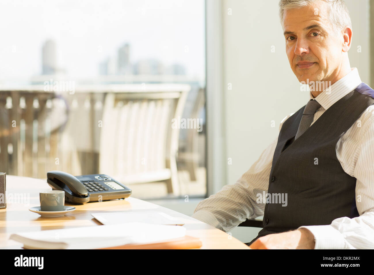 Businessman sitting at desk in office Stock Photo