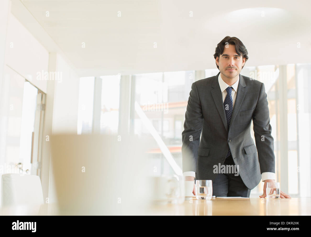 Businessman standing at conference table Stock Photo