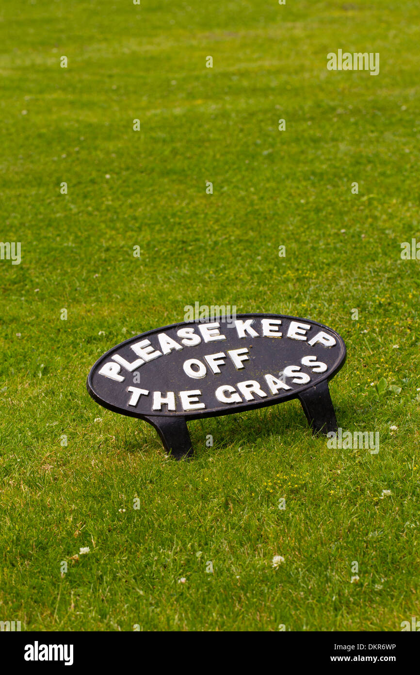 Cast iron 'Please Keep off the Grass' sign on a lawn. Dyfed, Wales. July. Stock Photo