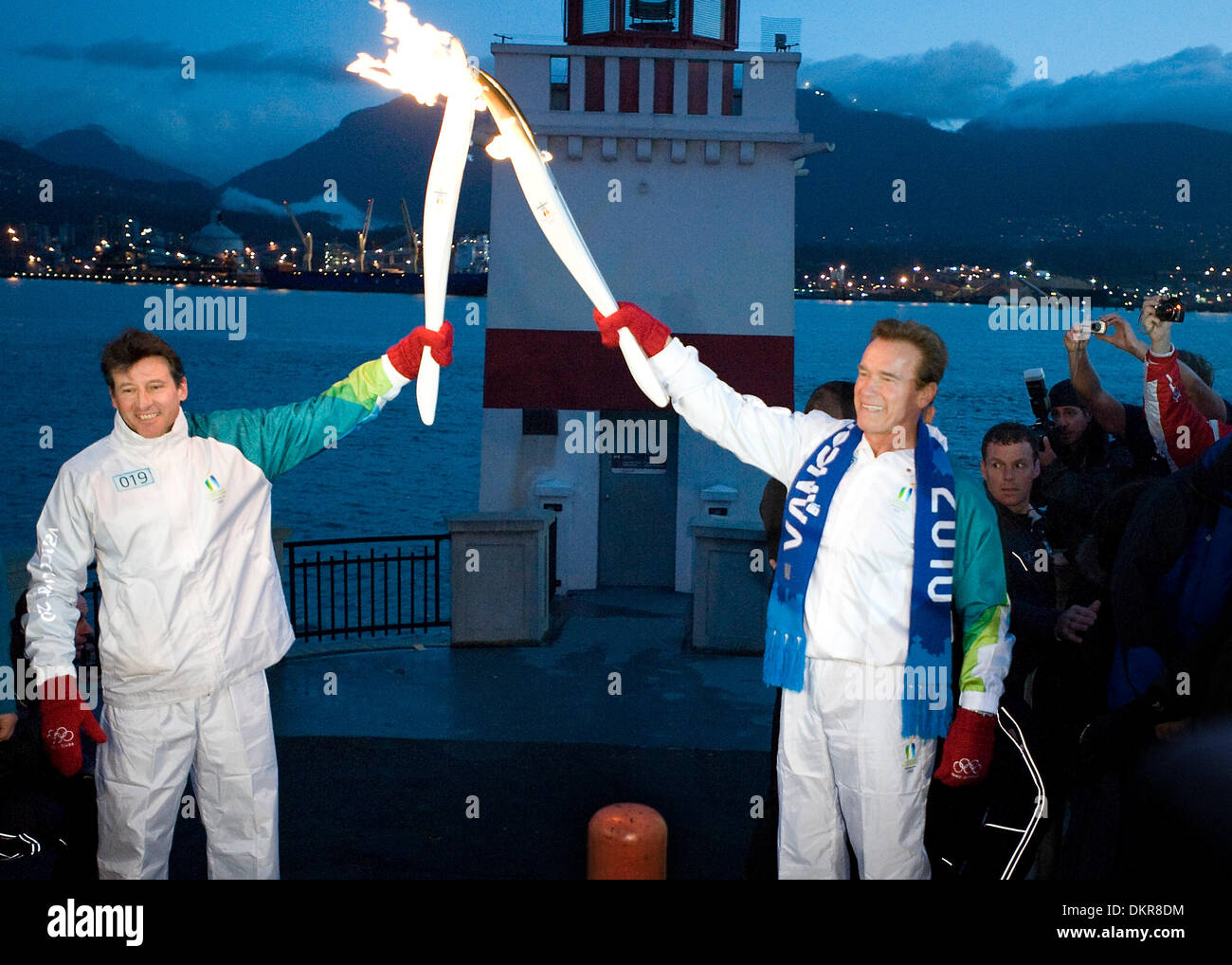 Feb. 12, 2010 - Vancouver, British Columbia, Canada - OLYMPIC TORCH - Governor Arnold Schwarzenegger hands off the Olympic torch to Sebastian Coe on Friday morning, the day of the opening ceremony at the Vancouver Games  at Vancouver's Stanley Park Friday, February 12, 2010 as the flame makes its final pass through the city on its way to the Opening Ceremony of the 2010 Winter Olym Stock Photo