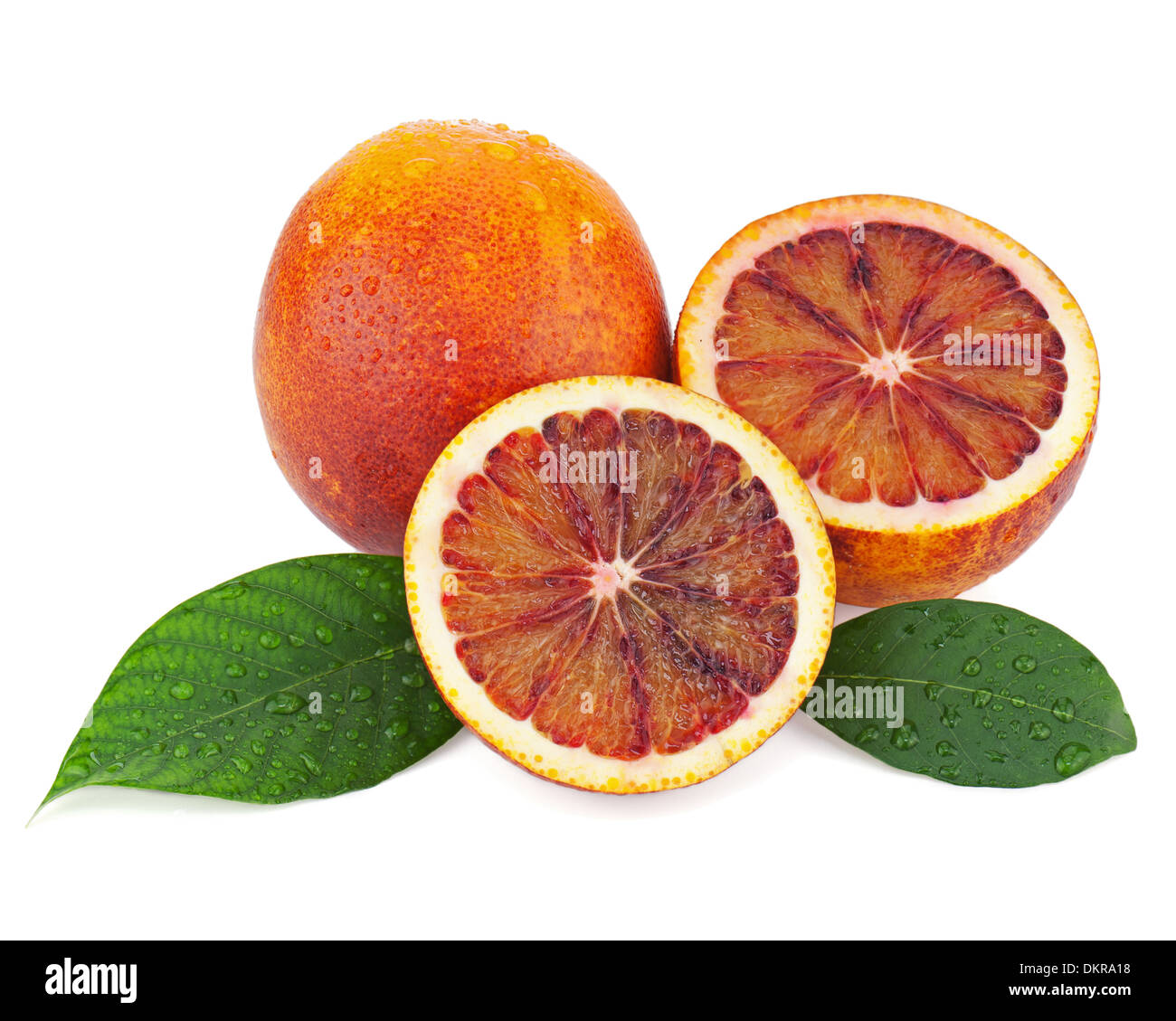 Ripe red blood oranges with cut and green leaves isolated on white background. Closeup. Stock Photo