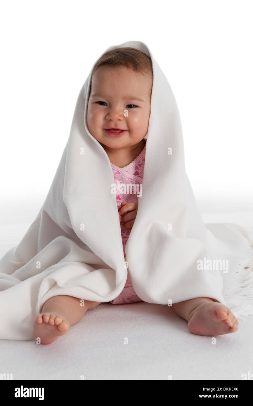 Happy toddler girl sitting on the floor on white background Stock Photo ...