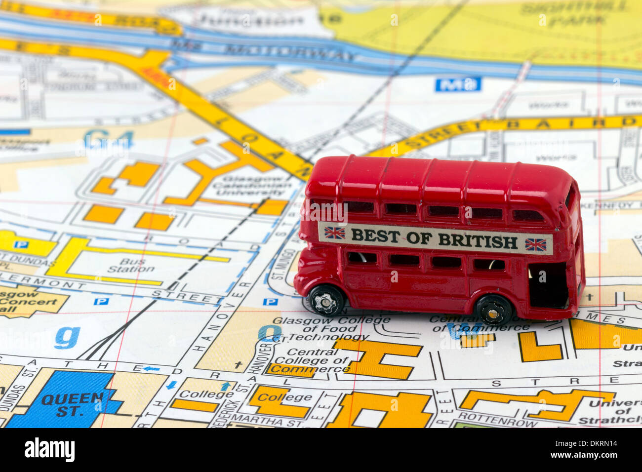 Toy Red Bus on Map en route to Bus Station Stock Photo
