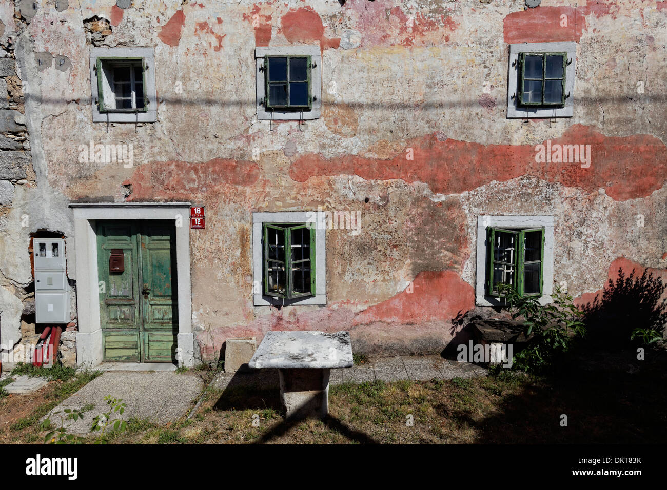 House with peeling walls and painted door, Kozina, Slovenia Stock Photo