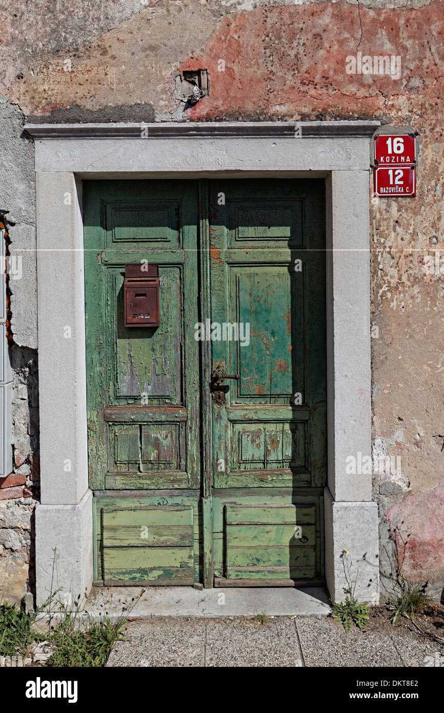 Door for house with fading peeling plaster, Kozina, Slovenia Stock Photo