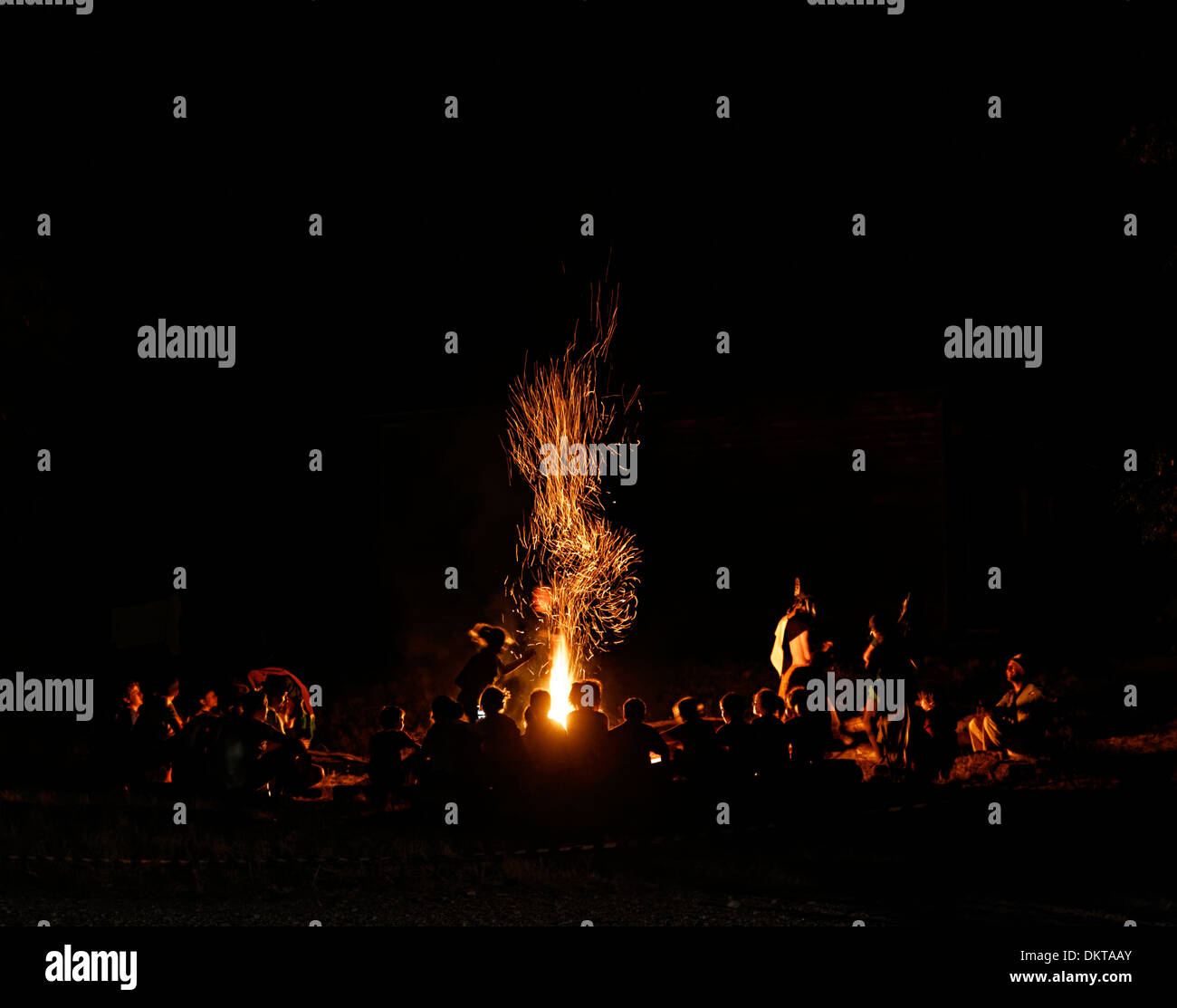 Scouts around a camp fire at night, Italy Stock Photo
