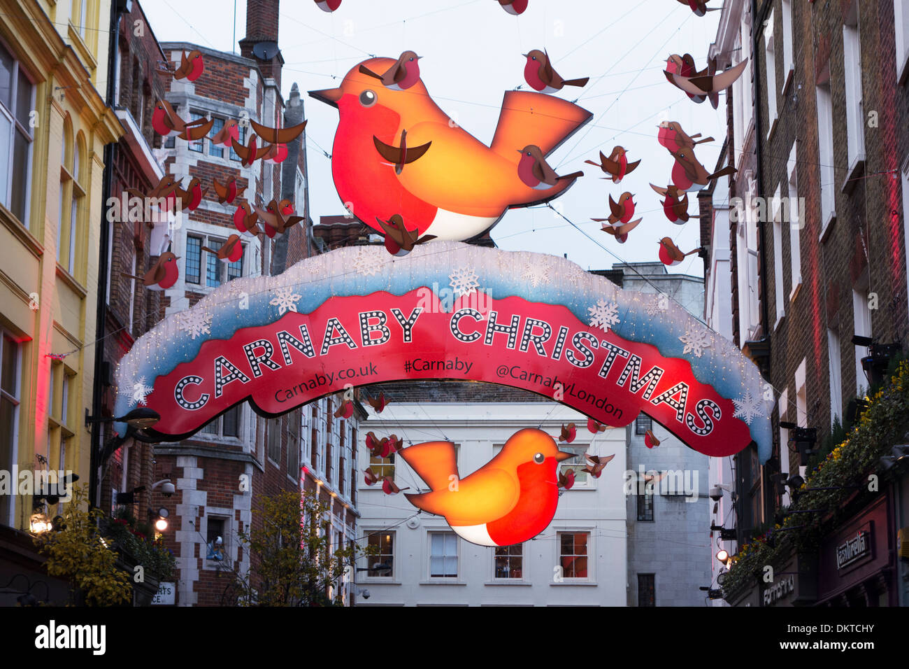 The 'Year of the Robin' Christmas decorations hang above Carnaby Street, London, England Stock Photo