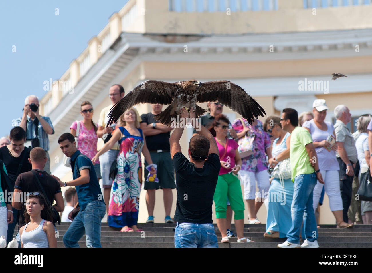 Hustlers on the Potemkin Stairs in Odessa selling tourists the opportunity to have a photograph taken with an eagle. Stock Photo