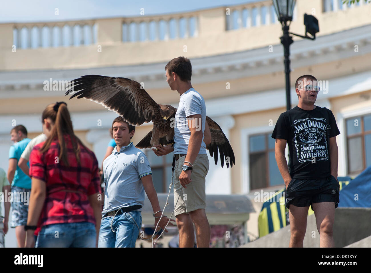 Hustler on the Potemkin Stairs in Odessa selling tourists the opportunity to have a photograph taken with an eagle. Stock Photo