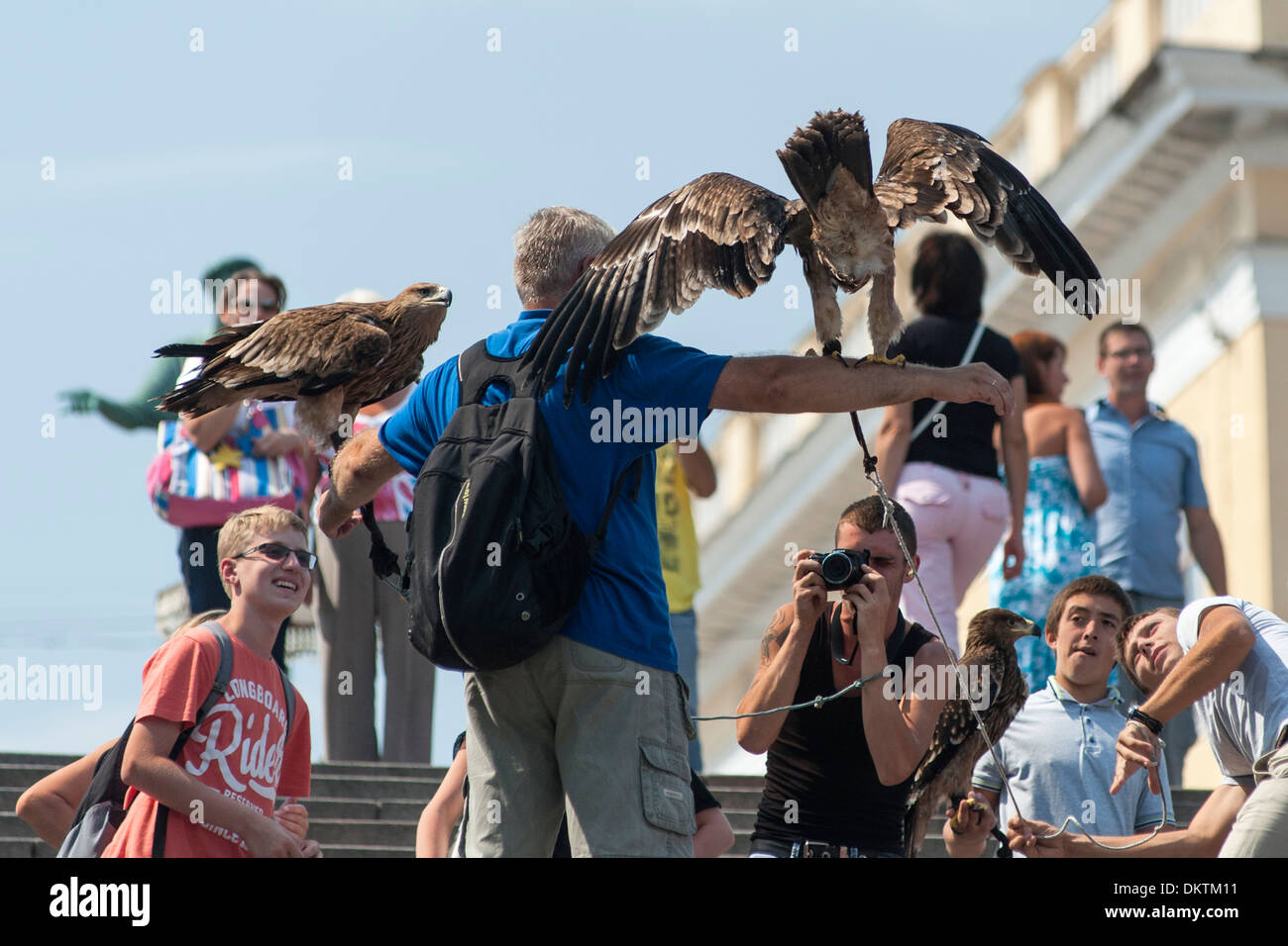 Hustlers on the Potemkin Stairs in Odessa selling tourists the opportunity to have a photograph taken with an eagle. Stock Photo