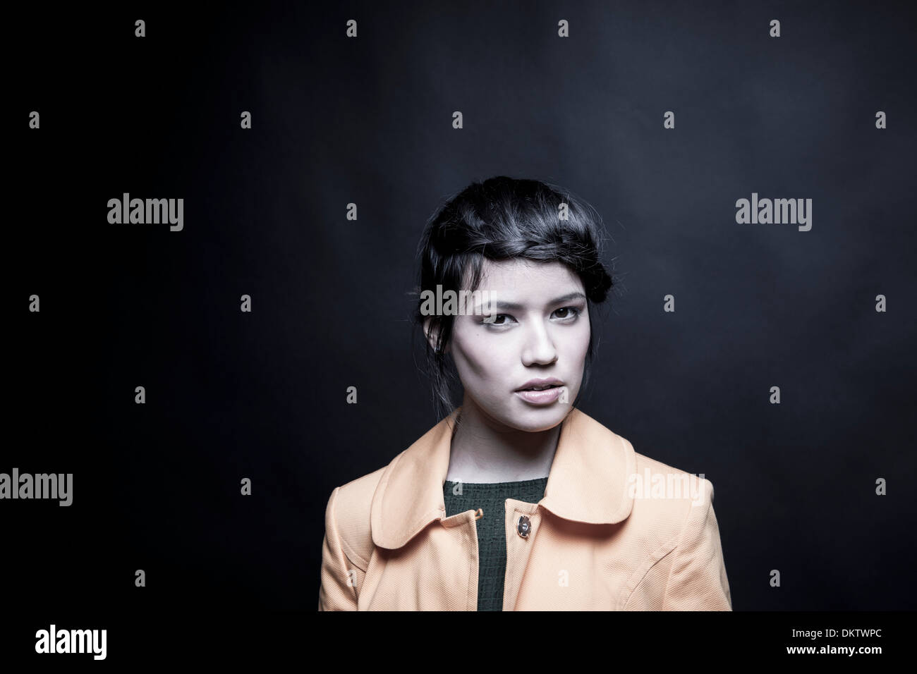 Studio portrait of young woman wearing yellow coat Stock Photo - Alamy