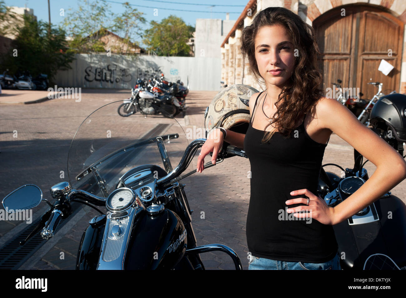 ATHENS, GREECE - OCTOBER 13: Young female stands by parked motorcycles in a Harley Davidson event in Athens on October 13, 2013 Stock Photo