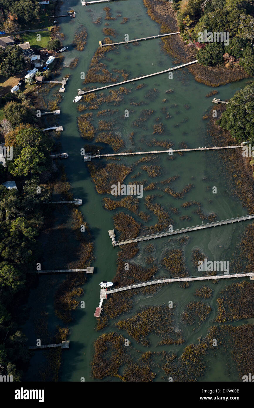 Aerial view of waterfront homes and long docks along the marsh in