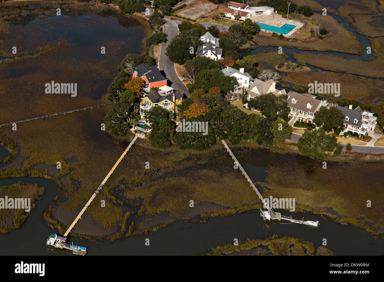 Aerial view of waterfront homes and long docks along the marsh in