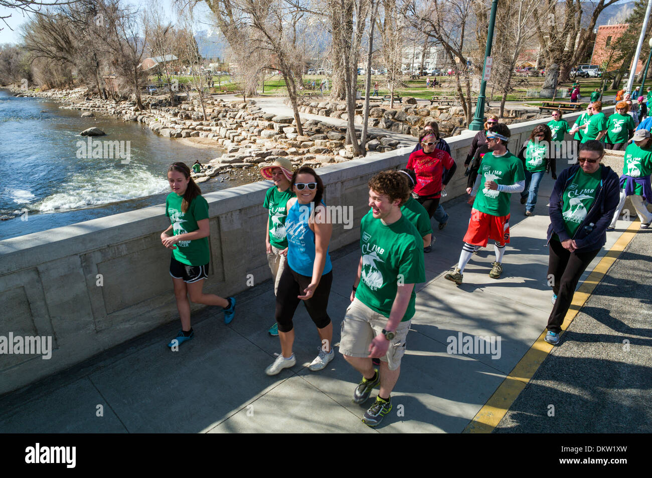 Participants walk cross the Arkansas River, F Street Bridge, during the Tenderfoot Cancer Climb fundraiser, Salida, Colorado USA Stock Photo