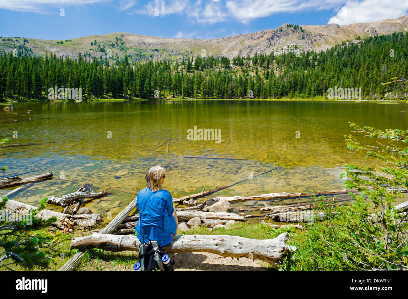 Female hiker enjoying the view at Waterdog Lake, a high alpine lake in the Colorado Rocky Mountains Stock Photo