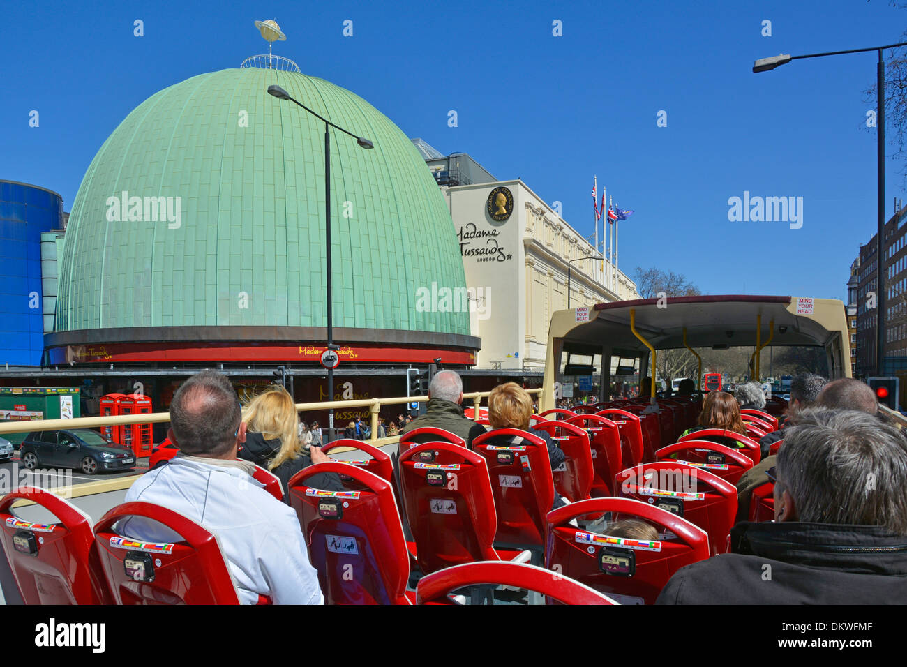 Tourists passengers open top sightseeing double decker tour bus &  green patina copper cladding dome of Madame Tussauds wax museum London England UK Stock Photo