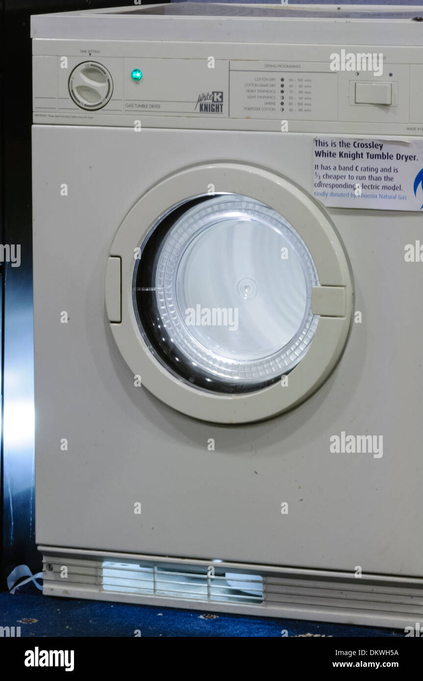 A tumble drier with the inner drum illuminated while in use Stock Photo