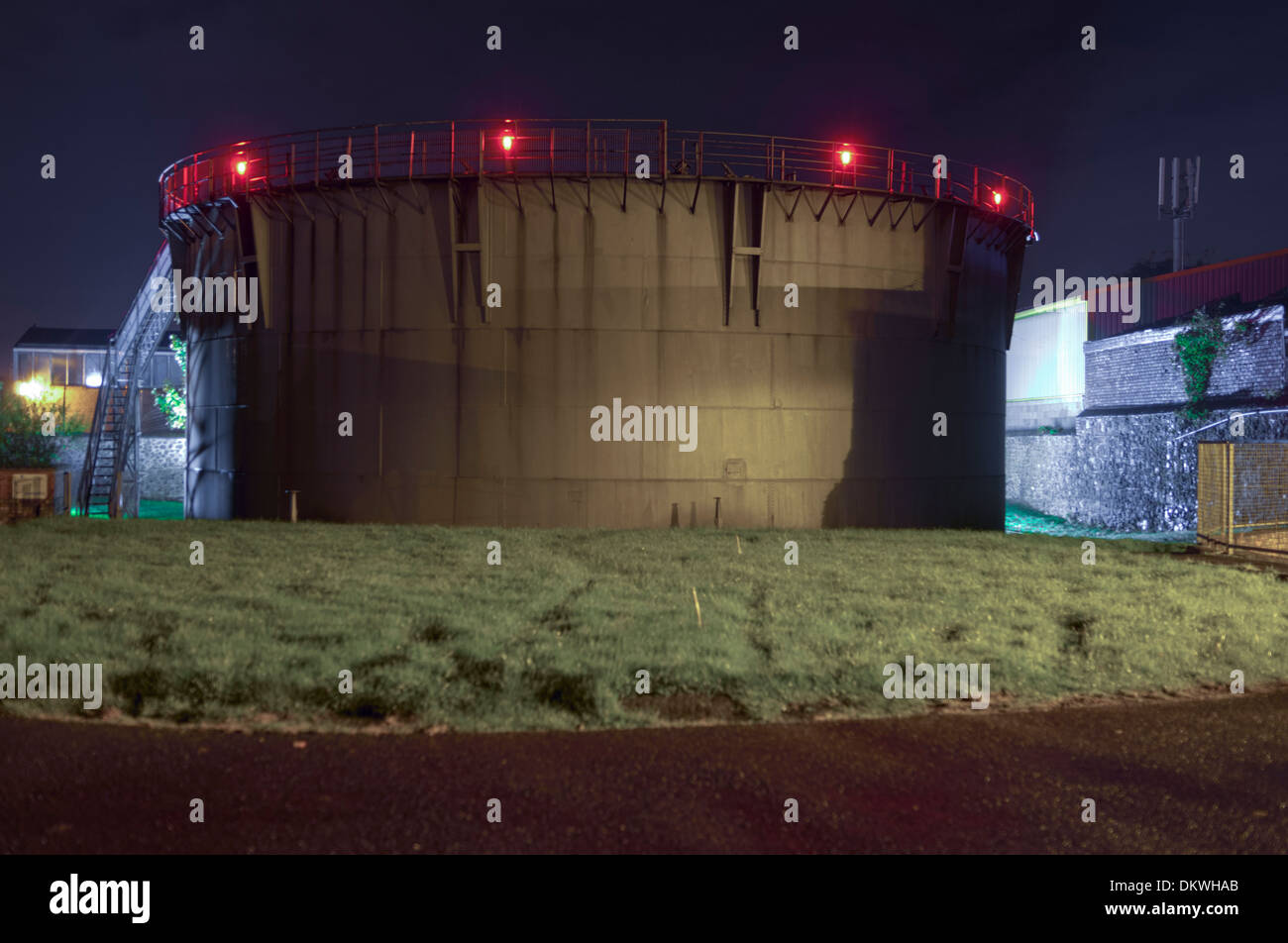 A gasometer at night, used in the storage and pressure regulation of the local gas supply Stock Photo