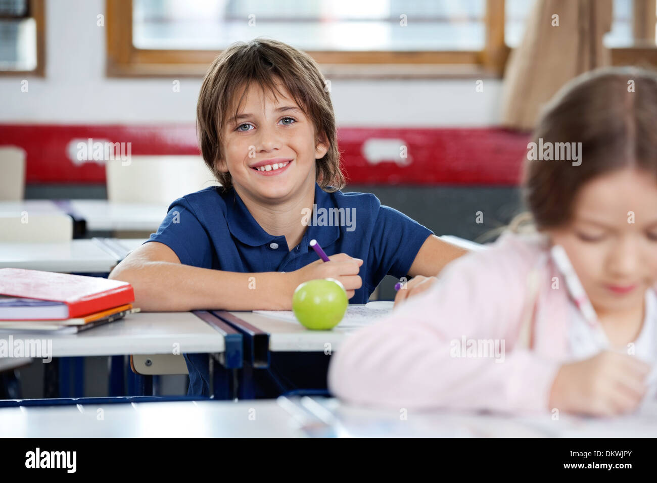 Portrait Of Happy Schoolboy Drawing At Classroom Stock Photo - Alamy