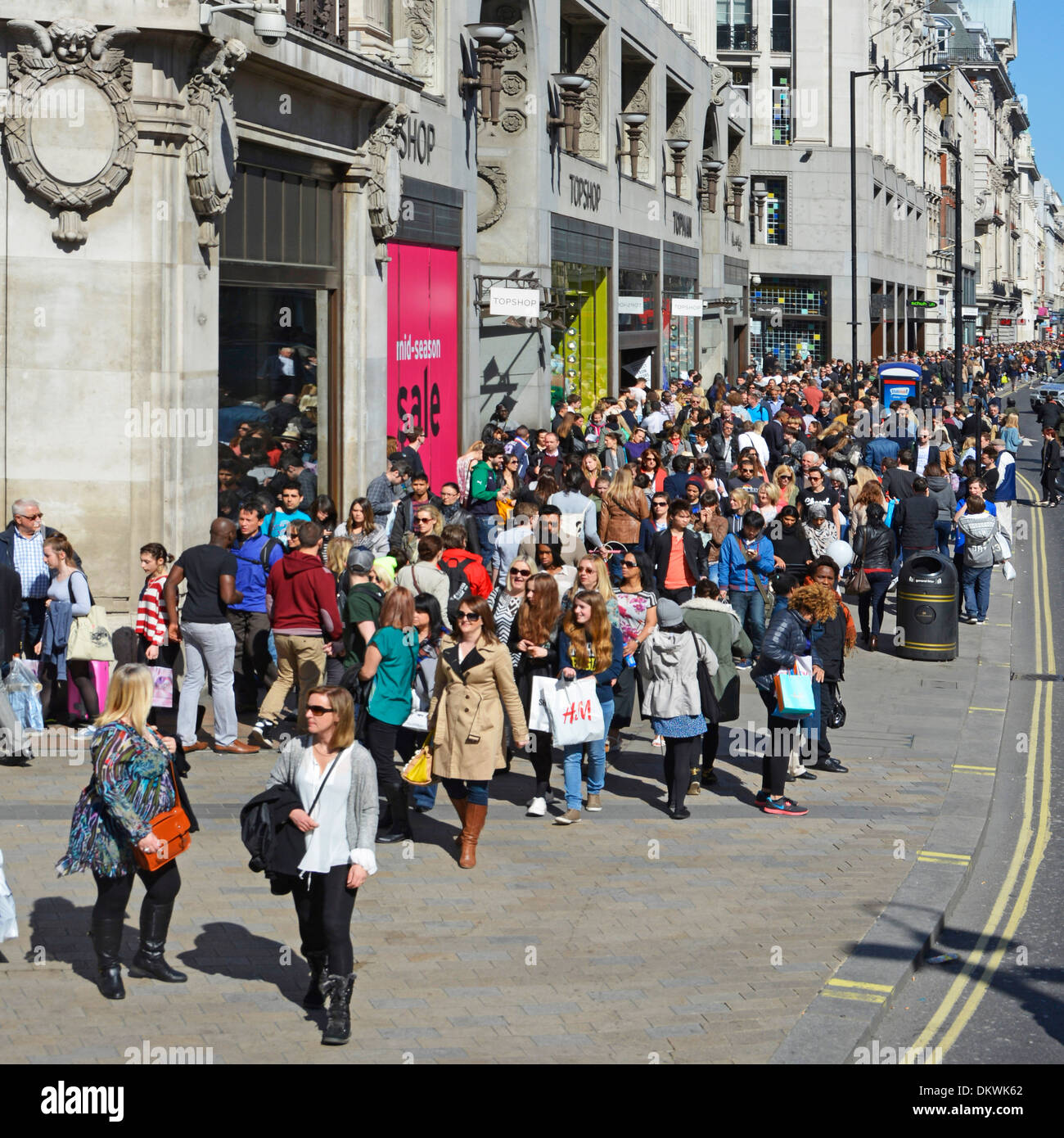 Crowd of people tourists & shoppers in busy London West End Oxford Street walking pavement outside Topshop store with sale on London England UK Stock Photo