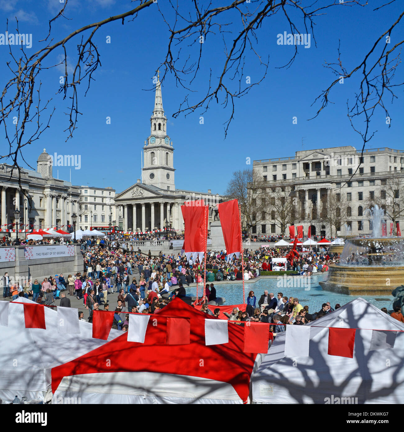 Red & white bunting at Mayor of London Feast of St George event & celebrations crowd of people blue sky spring day Trafalgar Square London England UK Stock Photo