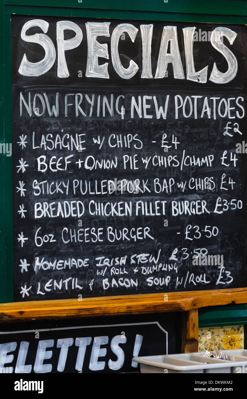 Blackboard at a 'greasy spoon' type cafe serving chips, lasagne, beef and onion pie, burgers, Irish stew and other food. Stock Photo