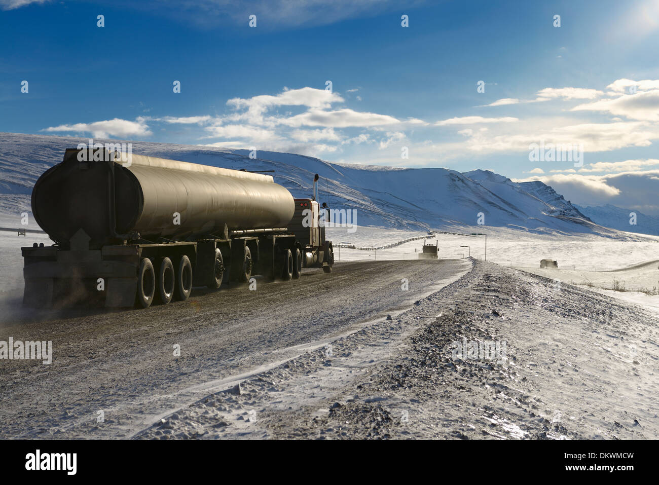 Tankers and trucks driving the Dalton Highway through the Brooks Range mountains Alaska USA Stock Photo