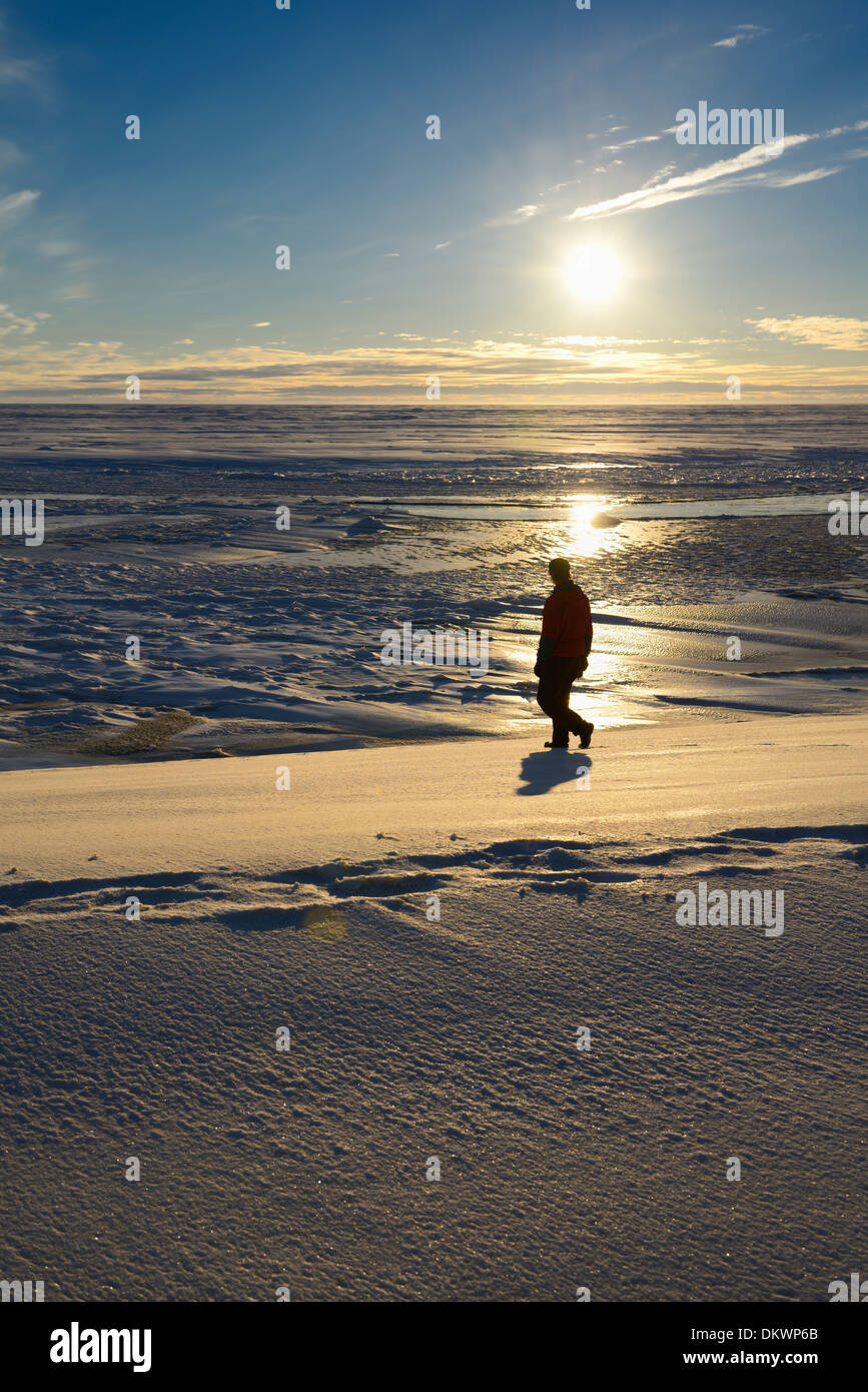 Man walking on the banks of the Sag river emptying into Prudhoe Bay Beaufort Sea Arctic Ocean Deadhorse Alaska USA Stock Photo