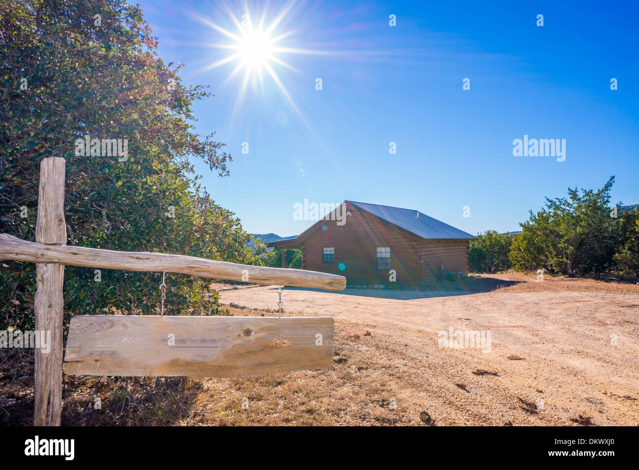 Canyon Breeze Cabin. Log home at remote location used as guest home. Sun with rays in the background, wooden name sign. Stock Photo