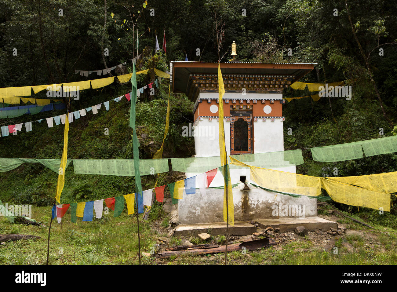 Bhutan, Trongsa, roadside water-powered prayer wheel with prayer flags on Yotang La Road Stock Photo