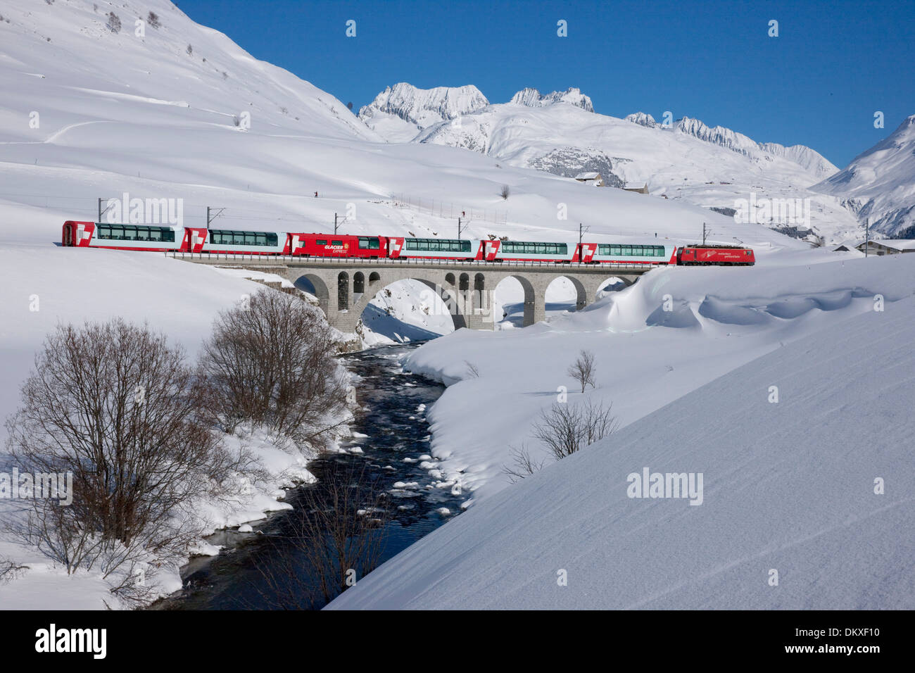 Switzerland Europe snow winter railway train railroad bridge canton UR Uri Ursenental Hospental Andermatt Glacier express brook Stock Photo