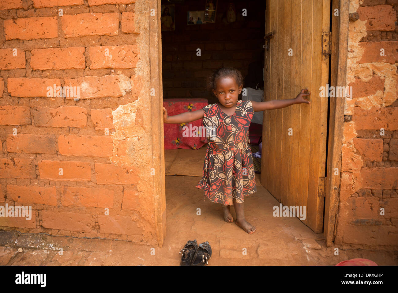 Child in the doorway of her home - Gombe, Uganda, East Africa Stock Photo