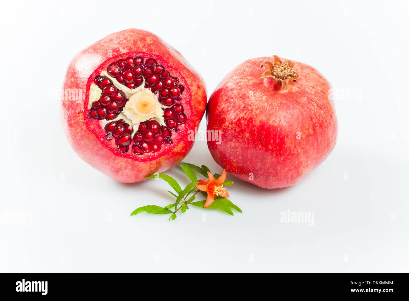 pomegranate fruit with cut, leaves and flower Stock Photo
