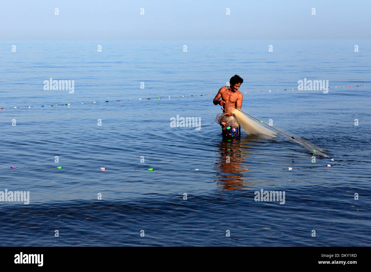 Balinese fisherman gathering his net, Anturan village, near Lovina, north Bali, Indonesia Stock Photo