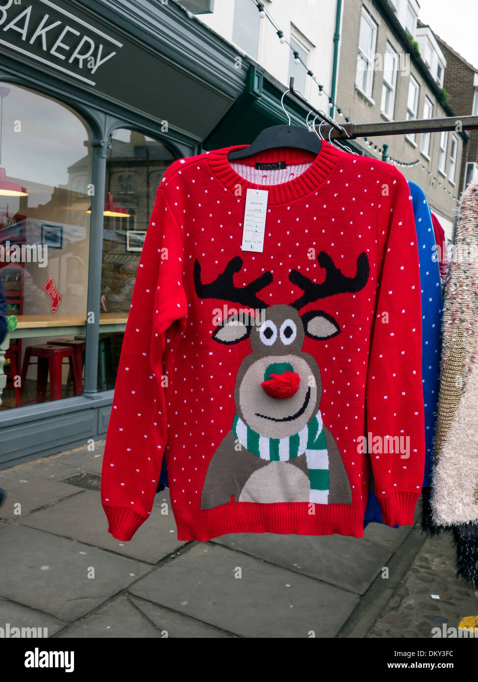 Market stall Christmas novelty sale red knitted jumper with smiling Rudolph the red nosed reindeer pattern Stock Photo