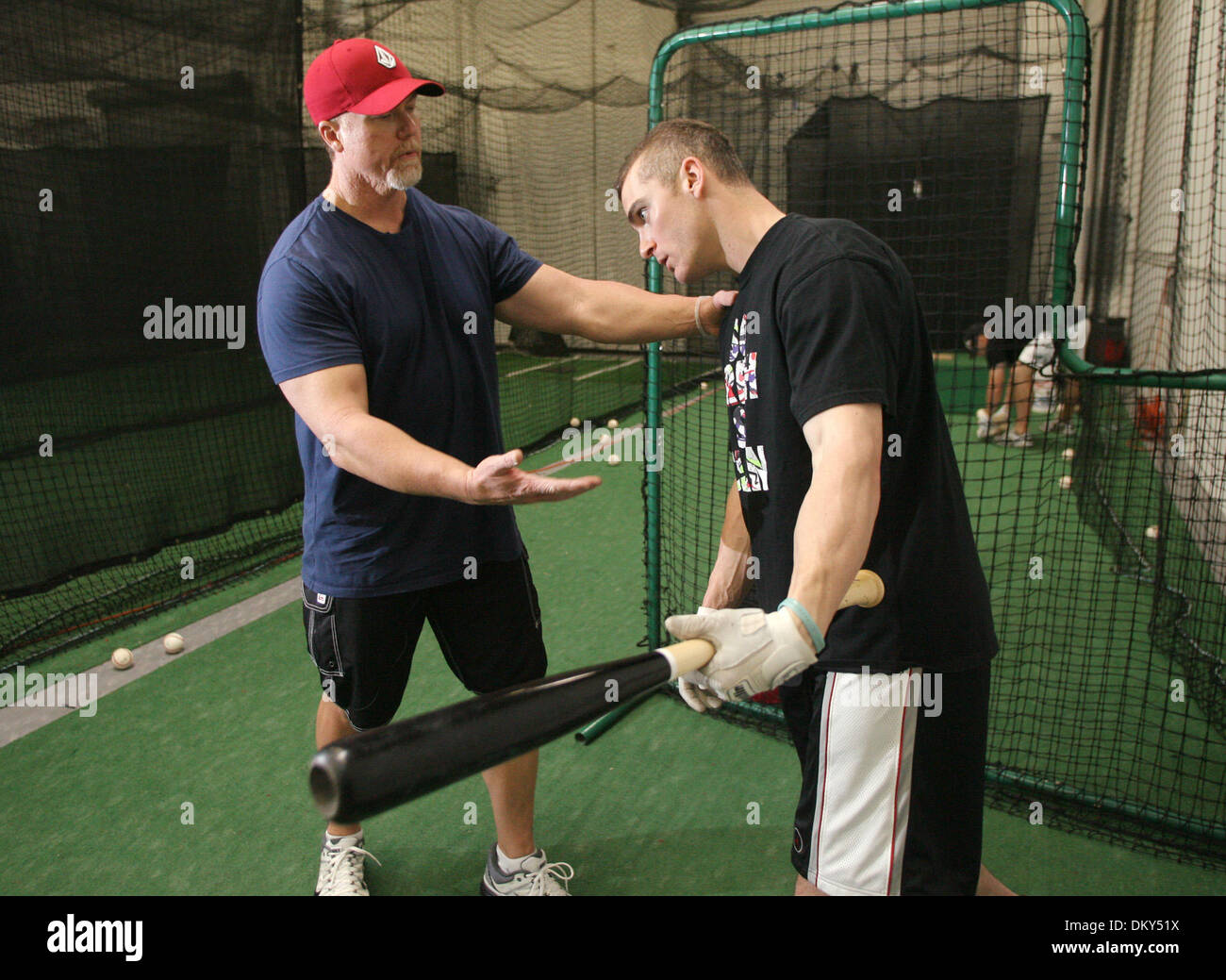 Jan 13, 2010 - Huntington Beach, California, USA - Cardinals hitting coach MARK MCGWIRE (left) works with infielder BRENDAN RYAN during a training session at a local baseball practice facility in Huntington Beach, Calif. The session with the Cardinals infielders was the first McGwire had had since his announcement Monday that he used performance enhancing drugs during his career. ( Stock Photo