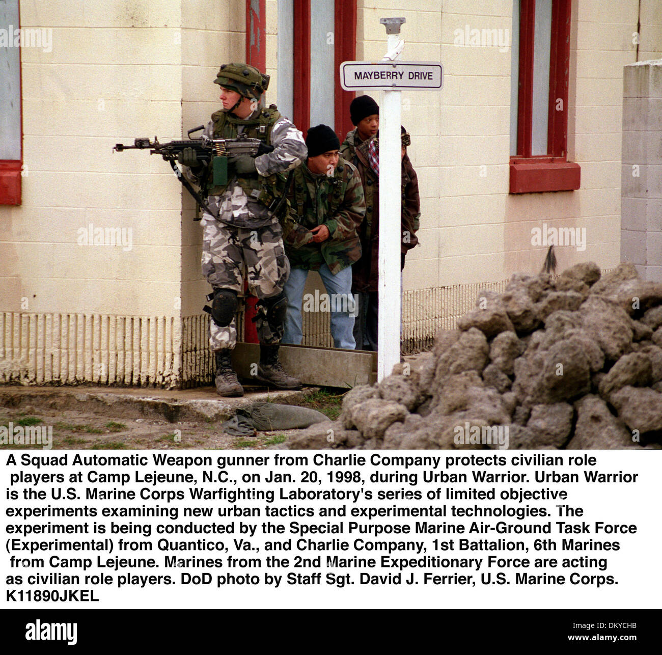 Jan. 1, 1998 - Camp Lejeune, NC, USA - A SAW (Squad Automatic Weapon) gunner from Charlie Company, 1st Battalion, 6th Marines, protects civilian role players at the MOUT (Military Operations in Urban Terrain) facility during LOE 1 (Limited Objective Experiment 1), which is part of the Marine Corps Warfighting Laboratory's Urban Warrior series.  (Released)(Credit Image: © Globe Phot Stock Photo