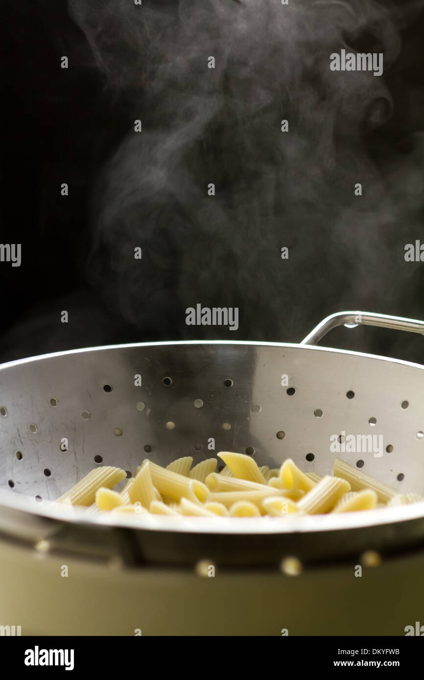 Cooked penne pasta draining in a colander Stock Photo Alamy