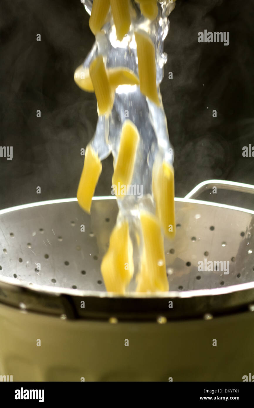 Pouring cooked penne pasta through a colander to drain Stock Photo Alamy