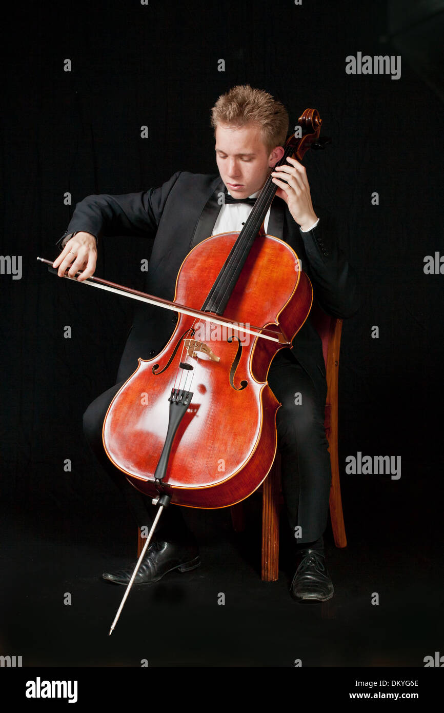 young caucasian cello player with black background Stock Photo