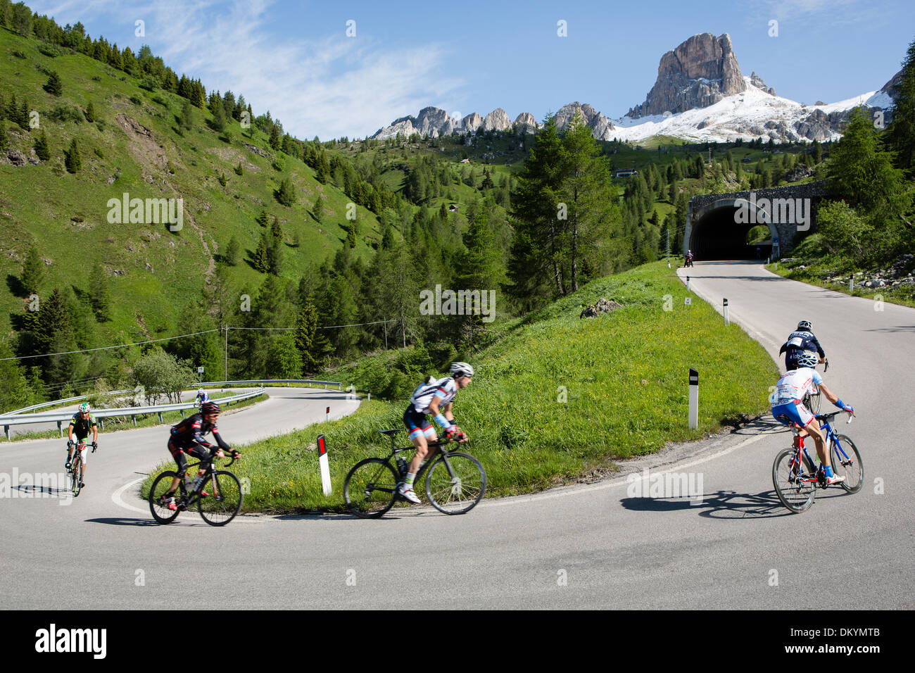 Pack of cyclists ride by a mountain during the Maratona dles Dolomites race in Italy, 2013 Stock Photo