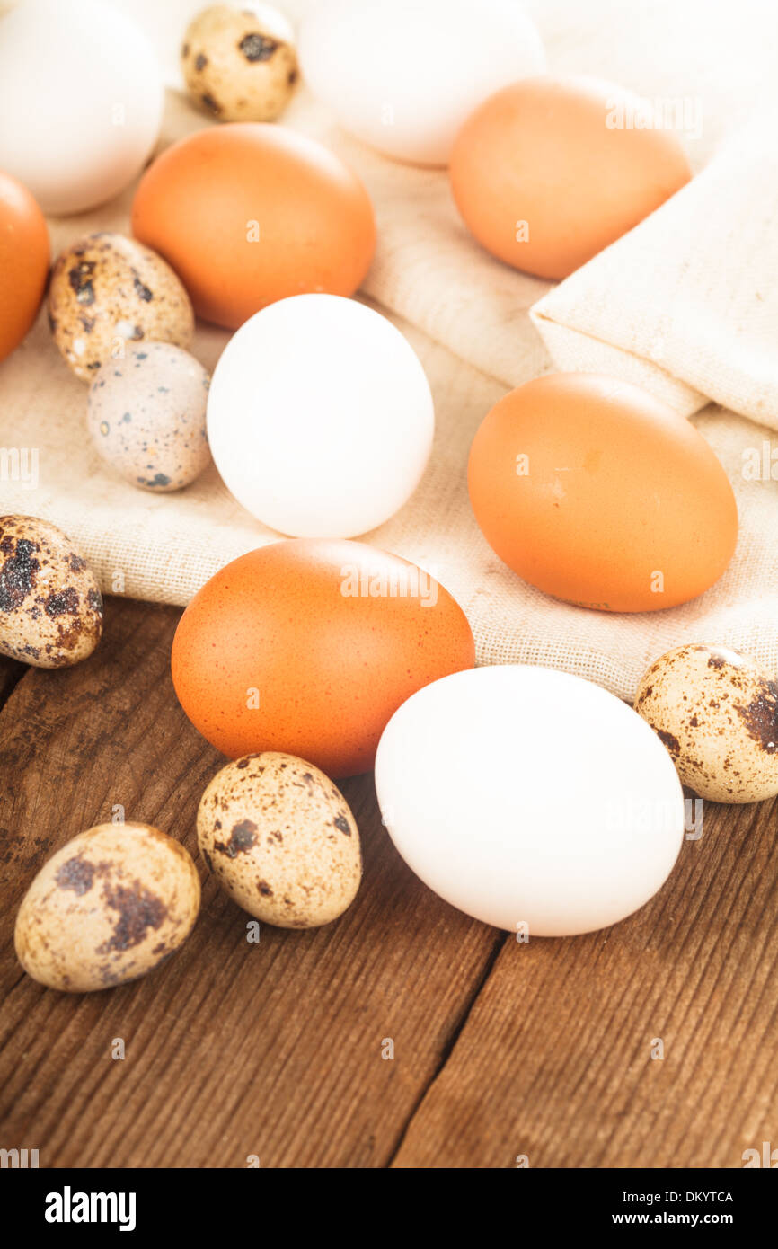 Eggs on textile tablecloth over rustic wooden table Stock Photo